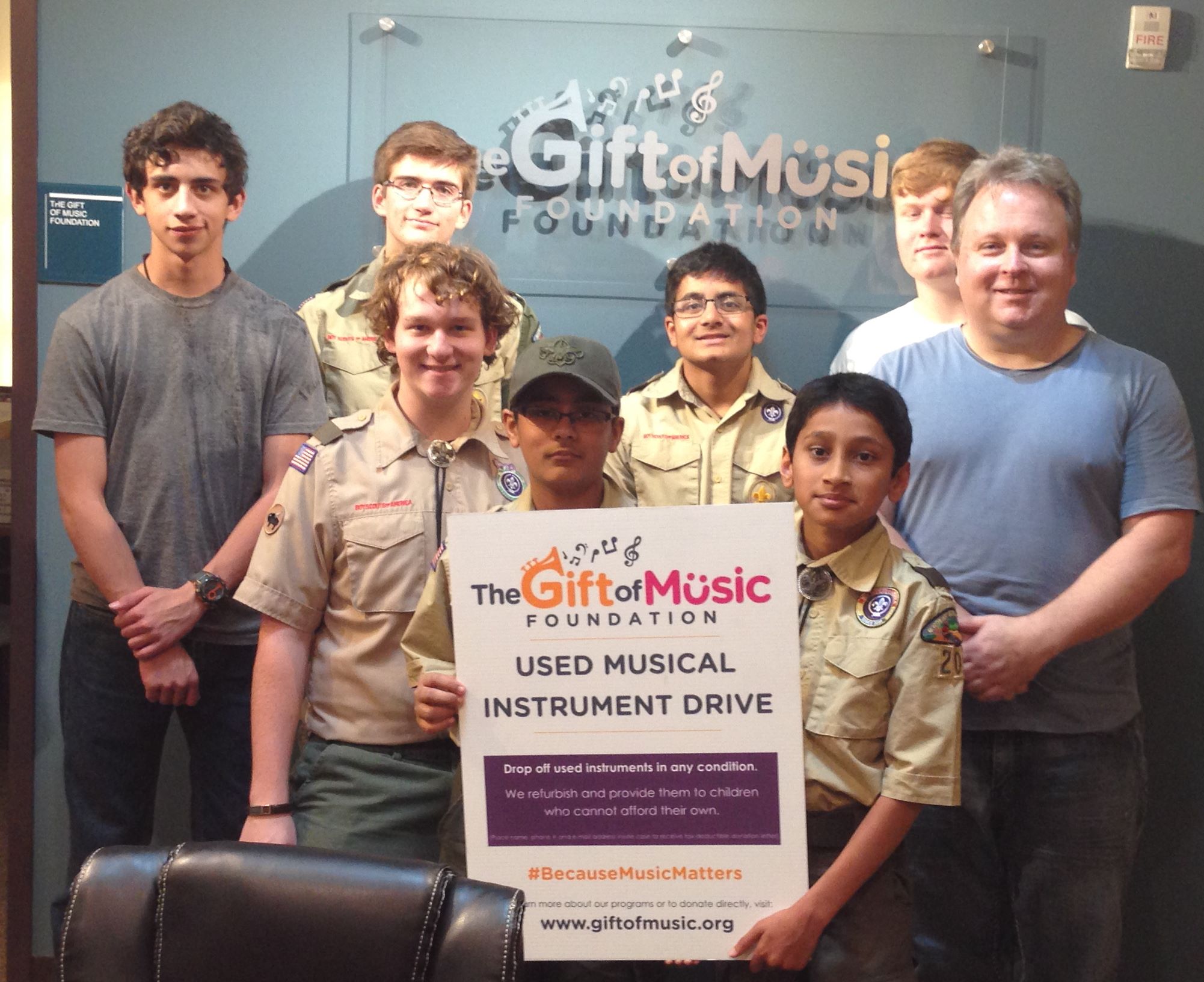 Scouts and Gift of Music Executive Director Chris Monroe celebrate instrument drive